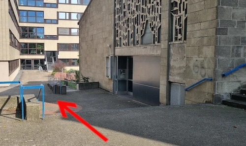 Dann gehe komplette an der Seite des Kirchengebäudes vorbei. Du findest dann hinten einen Bereich, wo sich Treppen nach unten befinden. Auf dem Weg dahin befindet sich ebenfalls eine kleine Treppe, wo es ein paar Stufen nach unten geht.